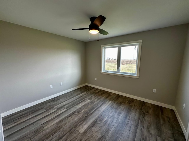 empty room with ceiling fan and dark hardwood / wood-style flooring