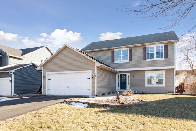 front of property featuring a front lawn and a garage