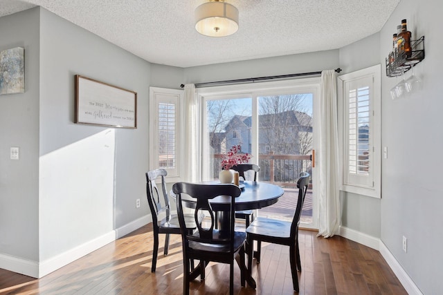 dining room with a textured ceiling and wood-type flooring