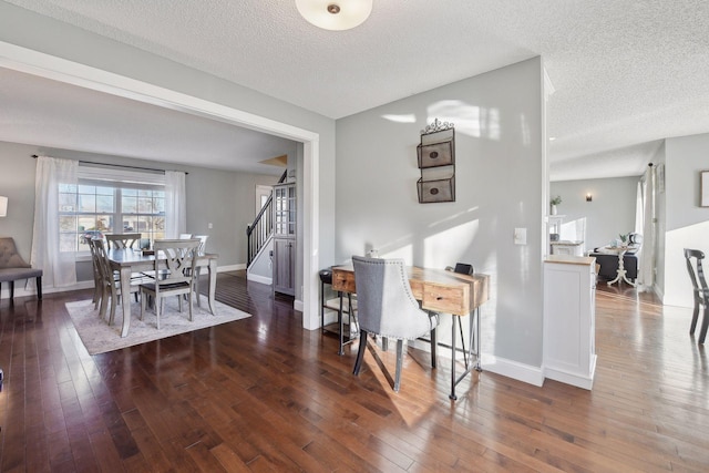 dining room featuring dark hardwood / wood-style flooring and a textured ceiling