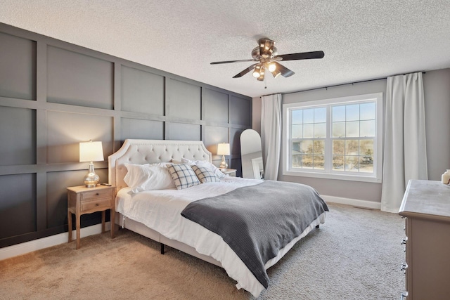 carpeted bedroom with ceiling fan and a textured ceiling