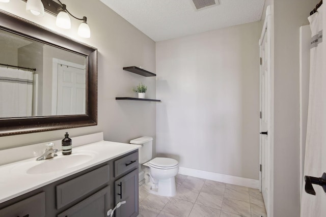 bathroom with a textured ceiling, toilet, and vanity