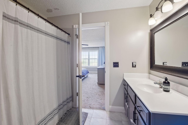 bathroom with a textured ceiling, a shower with shower curtain, tile patterned flooring, and vanity