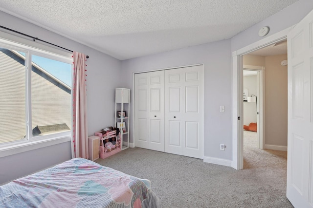 carpeted bedroom with a textured ceiling, a closet, and multiple windows