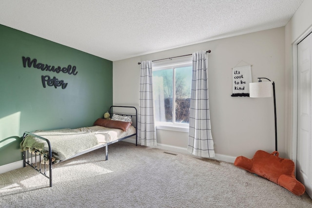 bedroom featuring a textured ceiling and carpet floors