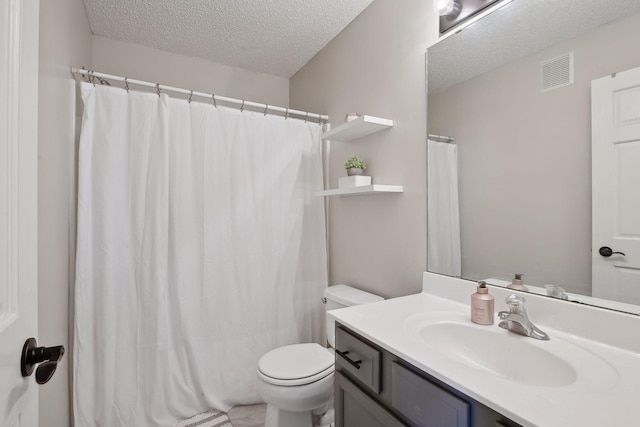 bathroom featuring a textured ceiling, toilet, and vanity