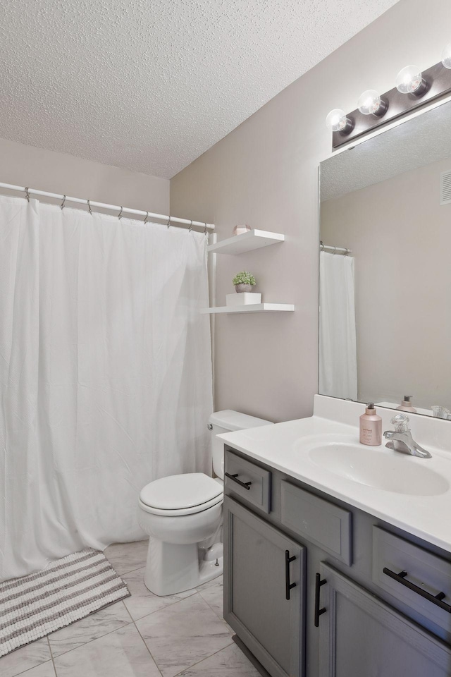 bathroom featuring a textured ceiling, toilet, and vanity