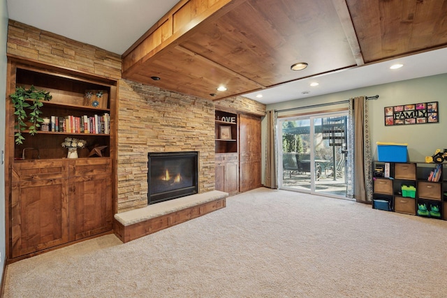 carpeted living room featuring wooden ceiling, a fireplace, and built in shelves