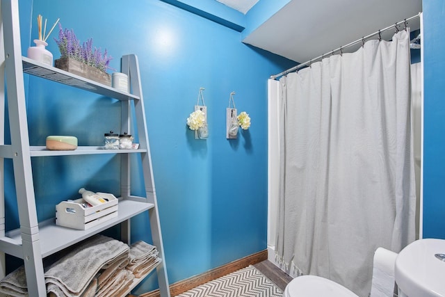 bathroom with toilet and a shower with shower curtain