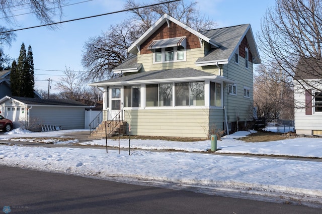 view of front of house featuring a sunroom and an outbuilding