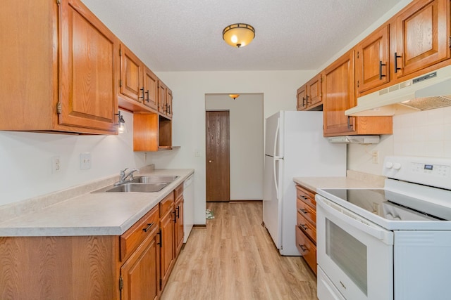 kitchen with a textured ceiling, sink, light hardwood / wood-style floors, and white appliances