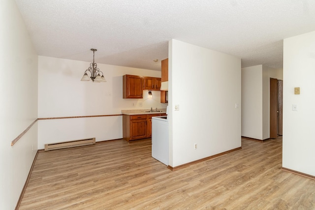 kitchen featuring light wood-type flooring, a baseboard heating unit, sink, decorative light fixtures, and a chandelier