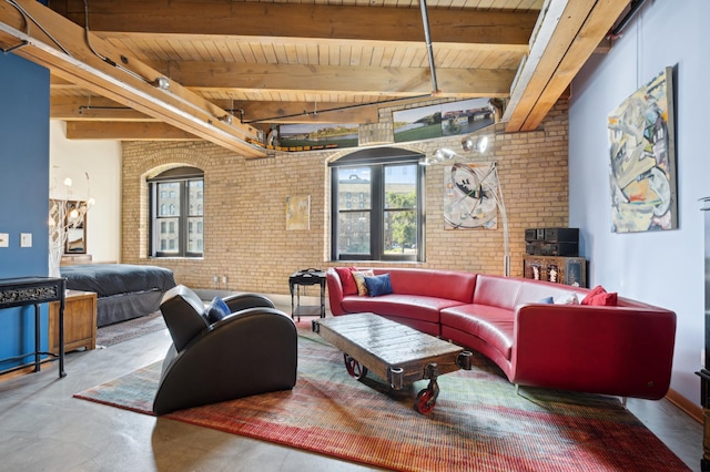 living room with beamed ceiling, wooden ceiling, brick wall, and concrete floors