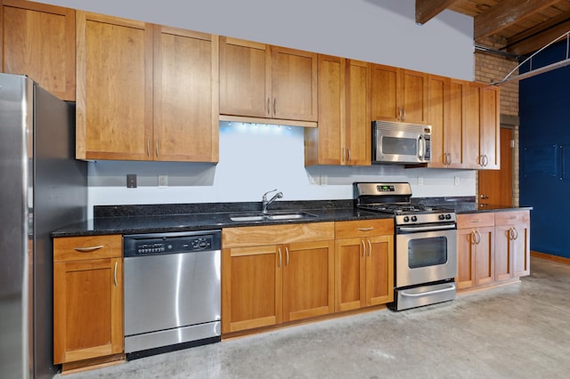 kitchen featuring beamed ceiling, appliances with stainless steel finishes, dark stone countertops, and sink