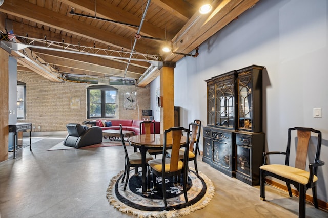 dining space with wooden ceiling, beamed ceiling, and brick wall