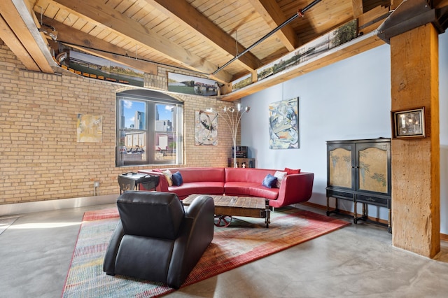 living area with concrete flooring, wooden ceiling, beamed ceiling, and brick wall