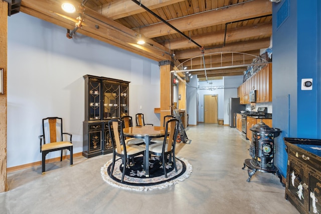 dining area with wooden ceiling, concrete floors, baseboards, and beam ceiling