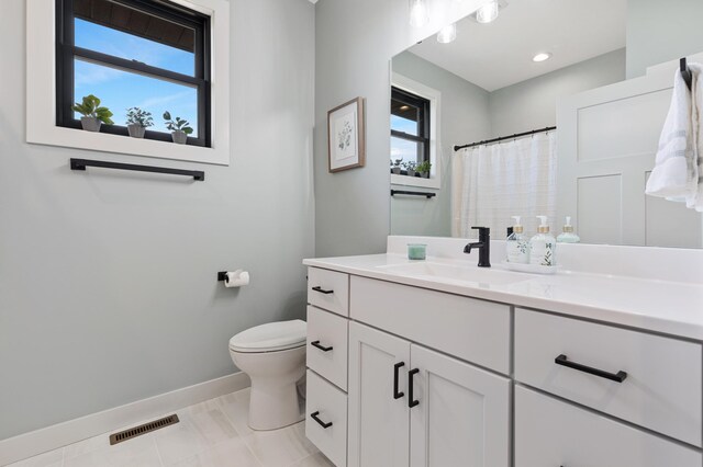 bathroom with tile patterned flooring, vanity, toilet, and a shower with shower curtain