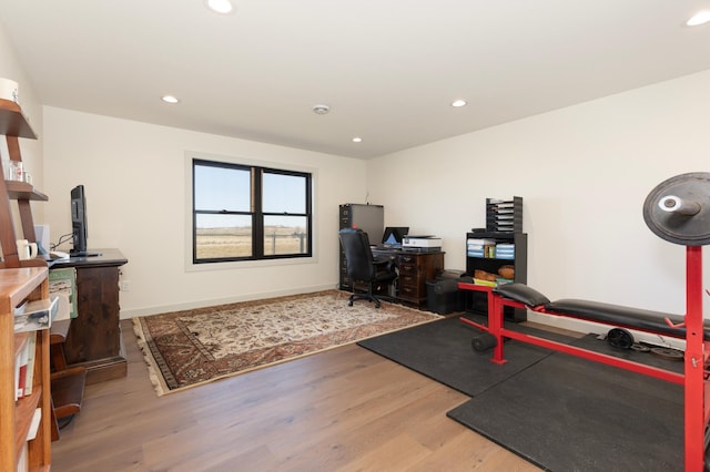 workout area with light hardwood / wood-style flooring