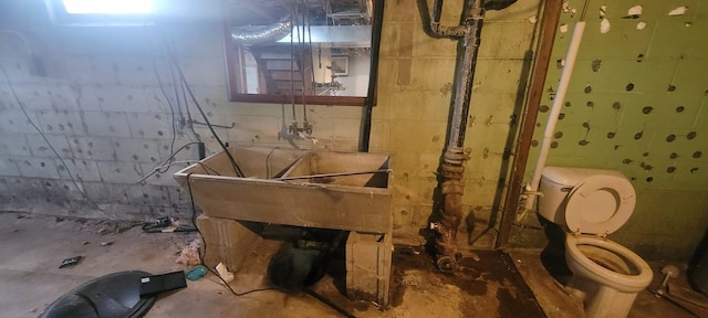 bathroom featuring concrete floors and toilet