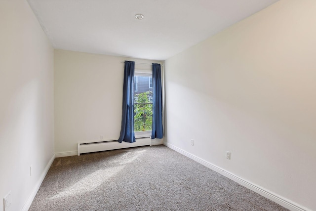 carpeted spare room with a baseboard radiator