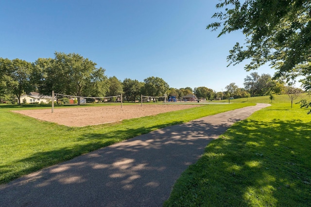 surrounding community with a lawn and volleyball court