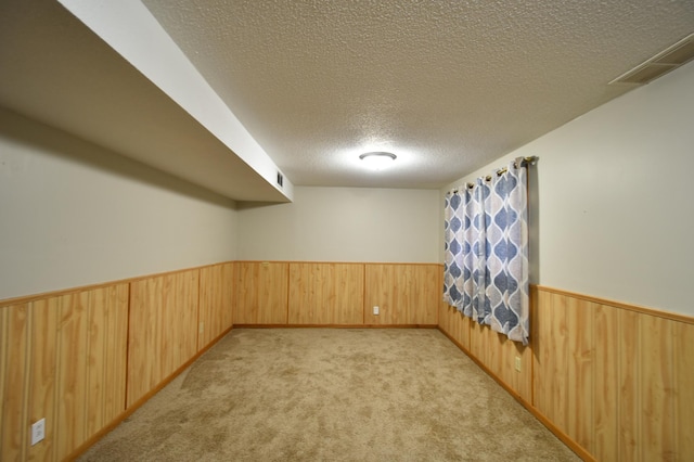 carpeted empty room with a textured ceiling