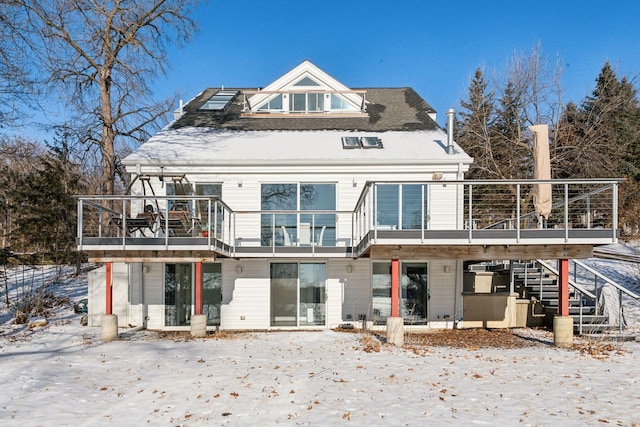 snow covered house with a wooden deck