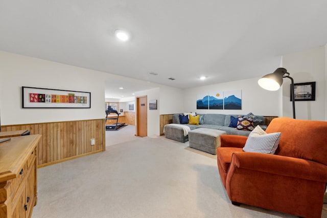 carpeted living room featuring wood walls