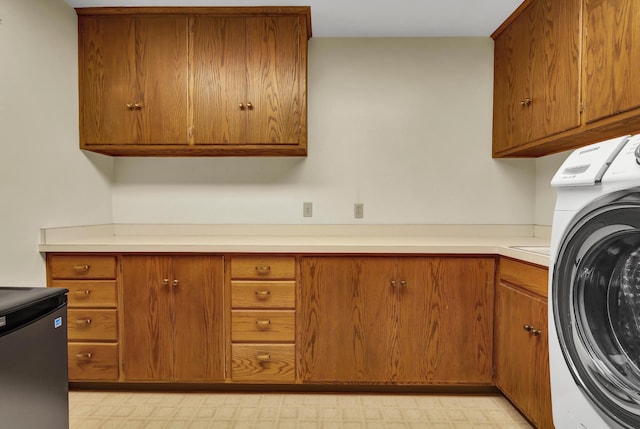 laundry room featuring cabinets and washer / clothes dryer