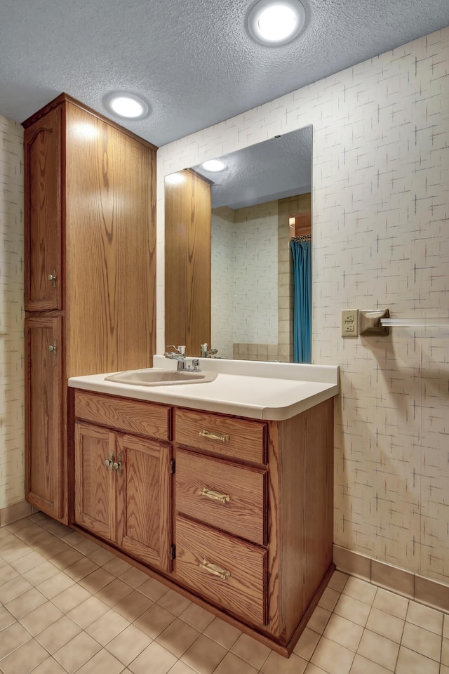 bathroom featuring vanity, tile patterned flooring, and a textured ceiling