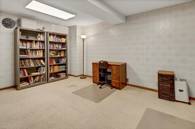 carpeted home office with beamed ceiling