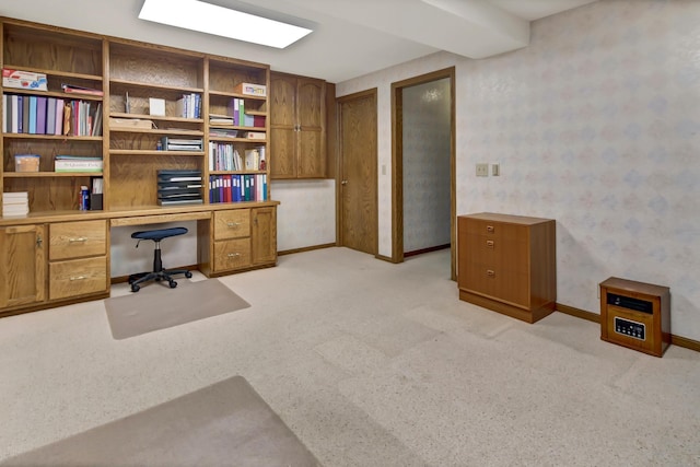 carpeted office featuring beam ceiling and built in desk