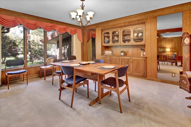 carpeted dining room with wooden walls and a chandelier