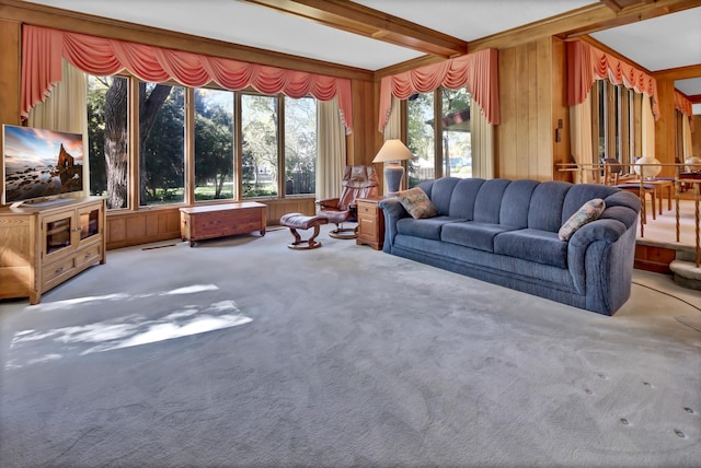 carpeted living room with beamed ceiling and wood walls