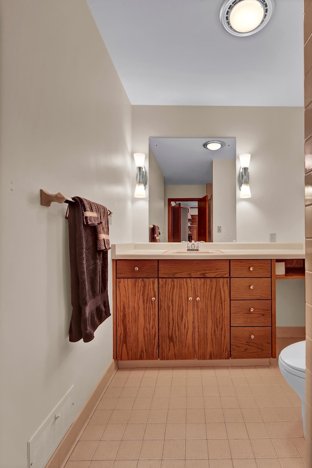 bathroom with tile patterned flooring, vanity, and toilet