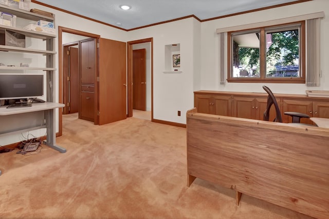 carpeted home office with ornamental molding and built in desk