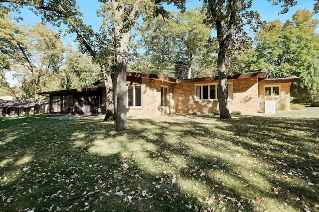 rear view of house featuring a yard