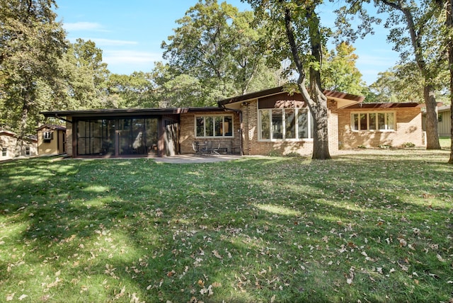 rear view of house with a lawn and a patio