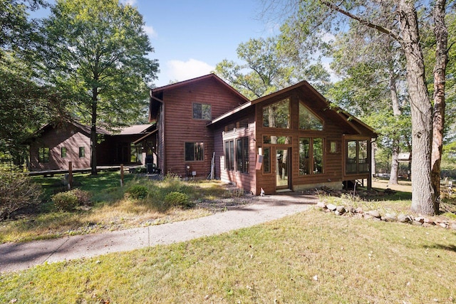 view of front of home featuring a sunroom and a front yard