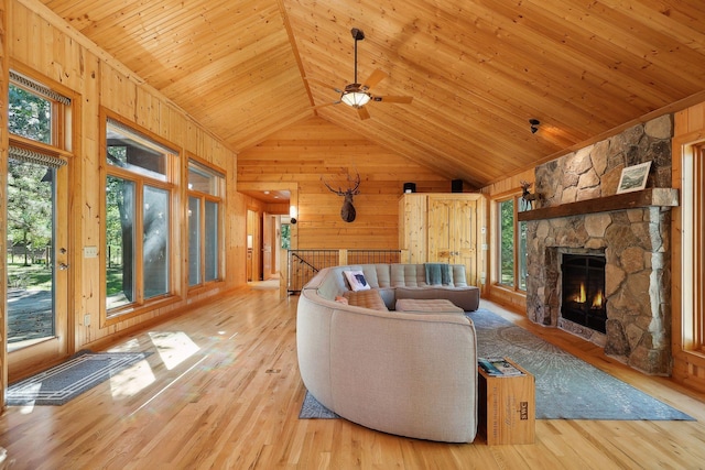 living room featuring wood walls, light wood-type flooring, and high vaulted ceiling