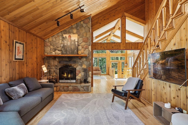 living room featuring wood walls, high vaulted ceiling, wood-type flooring, and track lighting