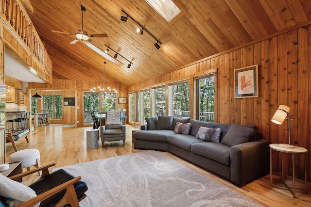 living room featuring a skylight, light wood-type flooring, wood ceiling, and track lighting