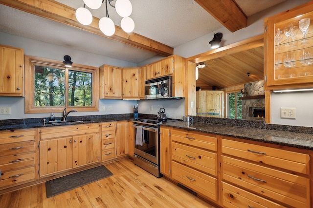 kitchen featuring a healthy amount of sunlight, sink, light wood-type flooring, and appliances with stainless steel finishes