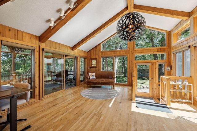 interior space featuring beam ceiling, a chandelier, a textured ceiling, and light wood-type flooring