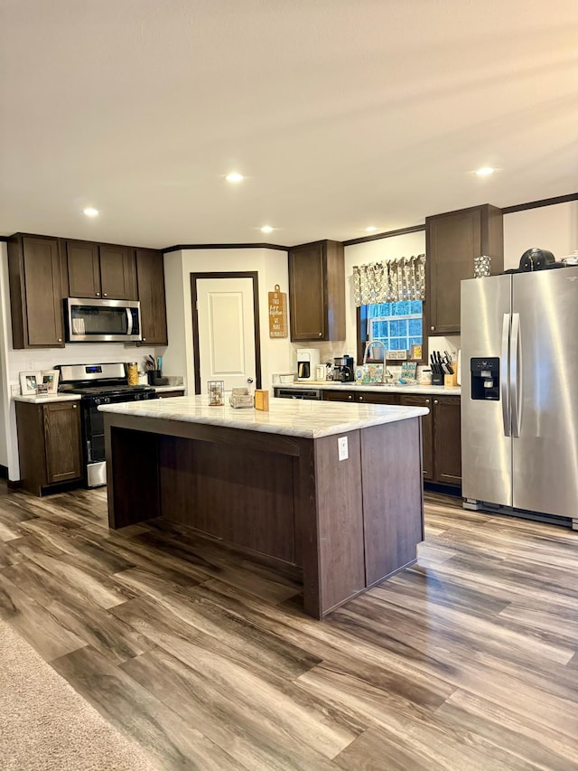 kitchen with a center island, dark brown cabinetry, and appliances with stainless steel finishes