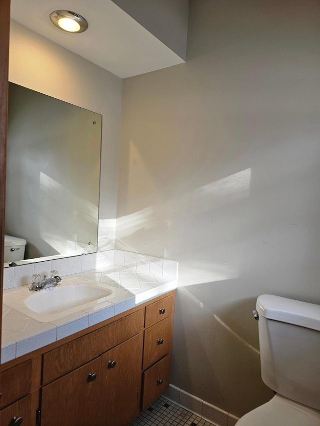 bathroom with tile patterned flooring, vanity, and toilet