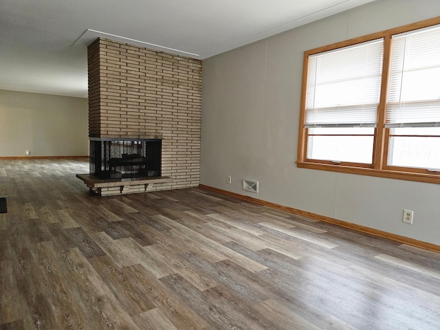 unfurnished living room with wood-type flooring and a fireplace