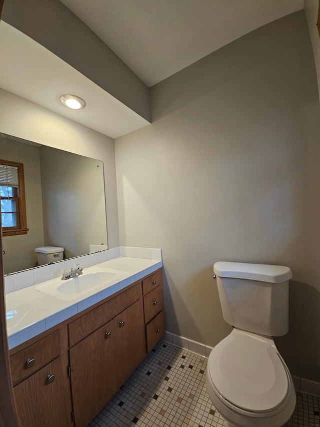 bathroom with tile patterned flooring, vanity, and toilet