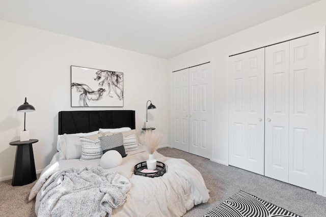 bedroom with carpet flooring and two closets